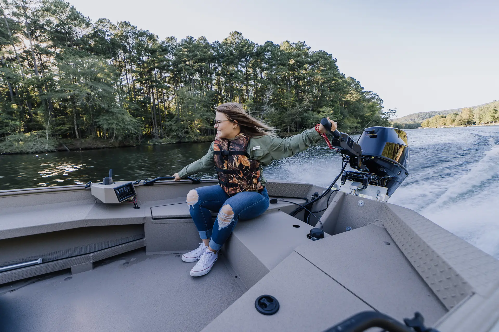 A woman smiling in an Alweld boat on the water
