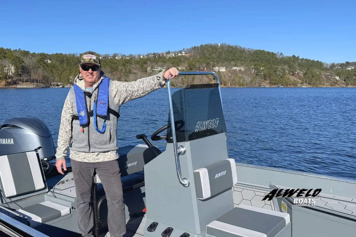 Solo angler preparing to launch aluminum fishing boat at boat ramp